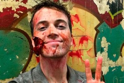 Male zombie actor giving peace sign