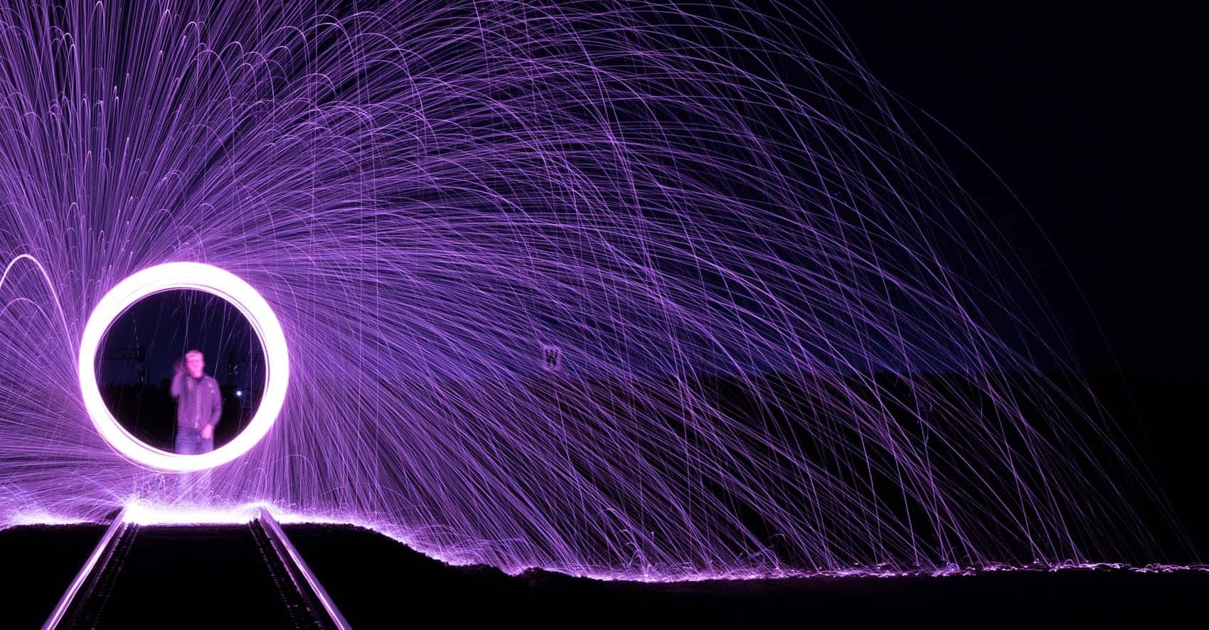 Person spinning sparker with purple sparks coming off