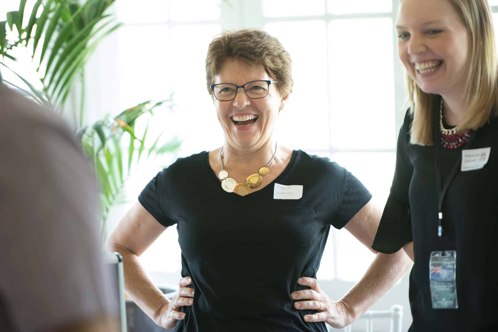 2 women laughing during a Directors of the Extraordinary corporate event