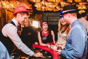 Guests laughing at a Blackjack table during Gatsby gambling night