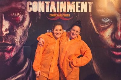 2 players posing in front of containment photo wall
