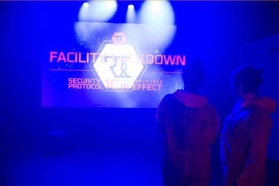 Facility lockdown on screen in lab lit blue during Containment game
