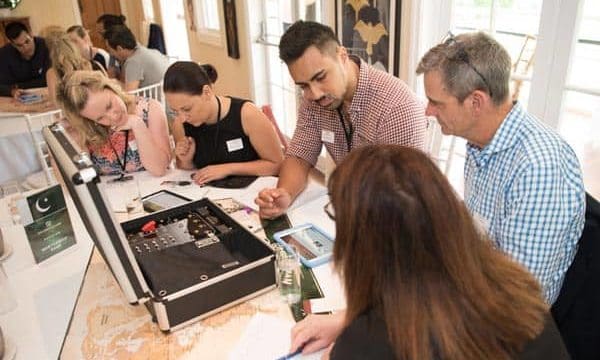 Mastership Game table of players Players solving spy puzzles during team building activity
