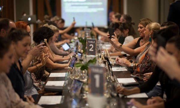 Table of guests taking selfies before wine tasting