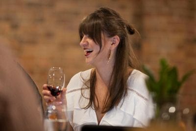 Woman laughing while drinking wine during game of wines