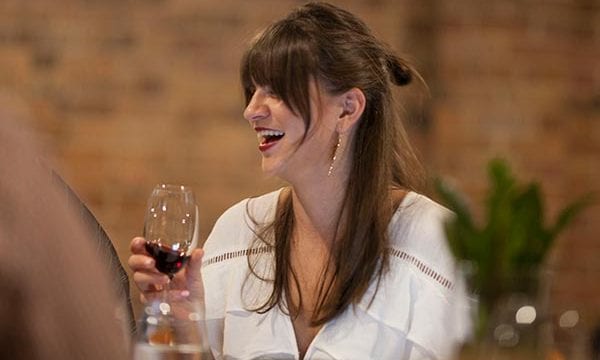 Woman laughing while drinking wine during game of wines