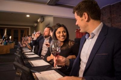 Guests holding wine smiling at each other during wine tasting