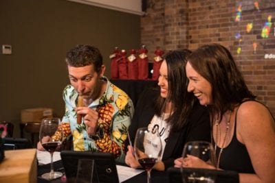 Out of the Bottle smelling Man smelling a vial while 2 people laugh