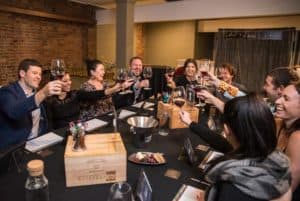 Table of guests cheers at wine tasting