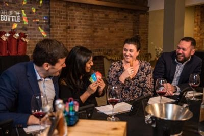 Out of the Bottle playing cards Guests sabotaging each other and laughing
