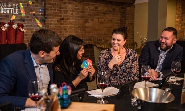 Out of the Bottle playing cards Guests sabotaging each other and laughing
