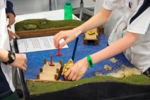 Close up of students solving river crossing puzzle