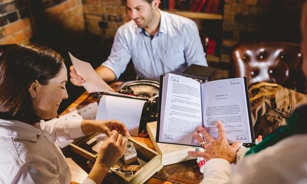 Reading a book with other players in the background