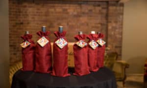 Bottles wrapped in red cloth for blind wine tasting event