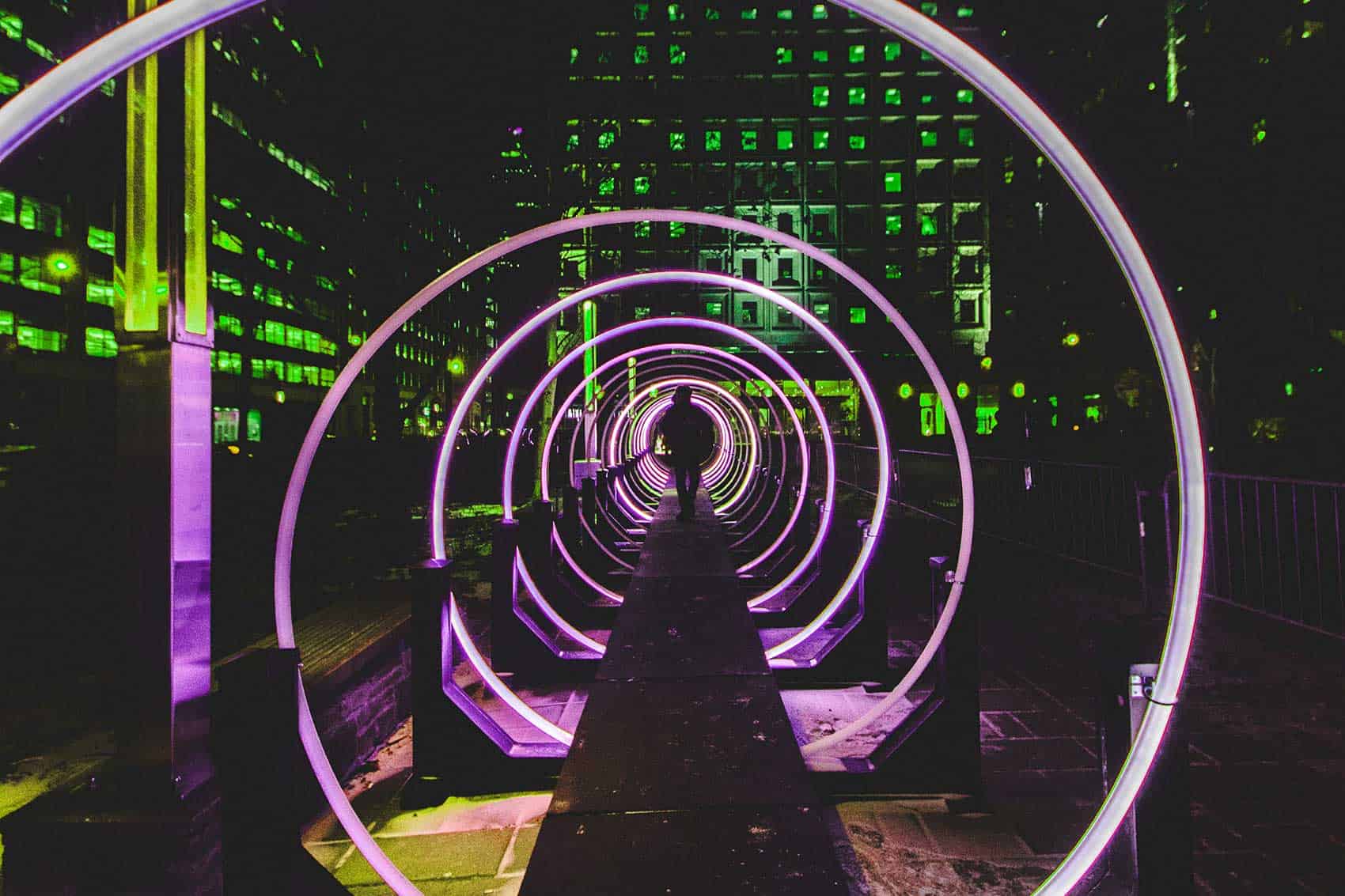 Person walking through purple neon circles