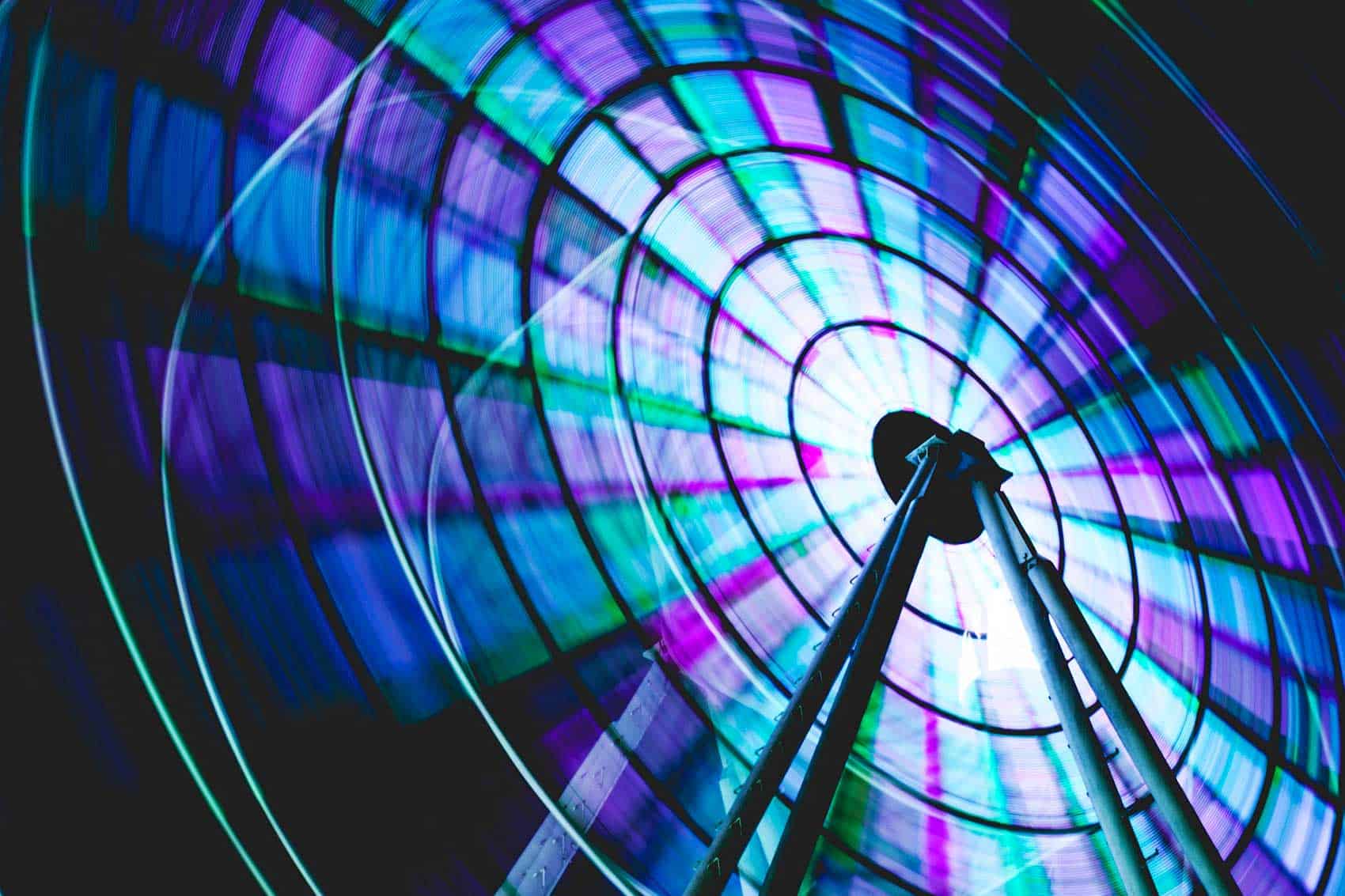 Blue and purple glowing ferris wheel at night