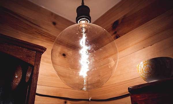 Giant vintage light bulb against wooden wall