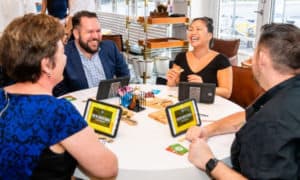 4 people at a table eating cheese and laughing