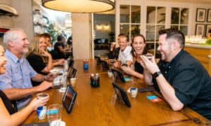 Guests laughing during tea tasting at a table