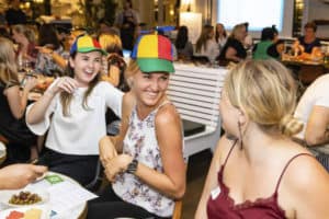 Women wearing helicopter hats and laughing during entertainement event